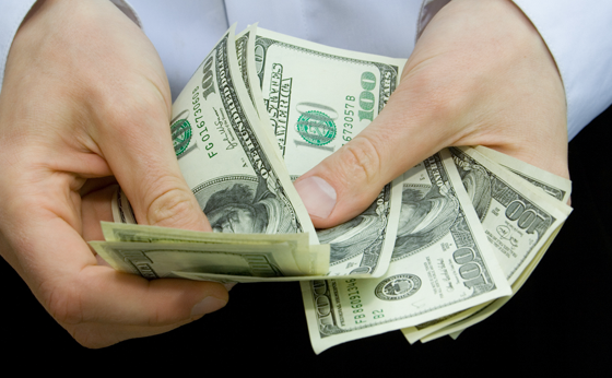 homem contanto notas de dólar
