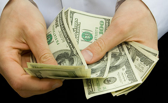pessoa contando notas de dólar